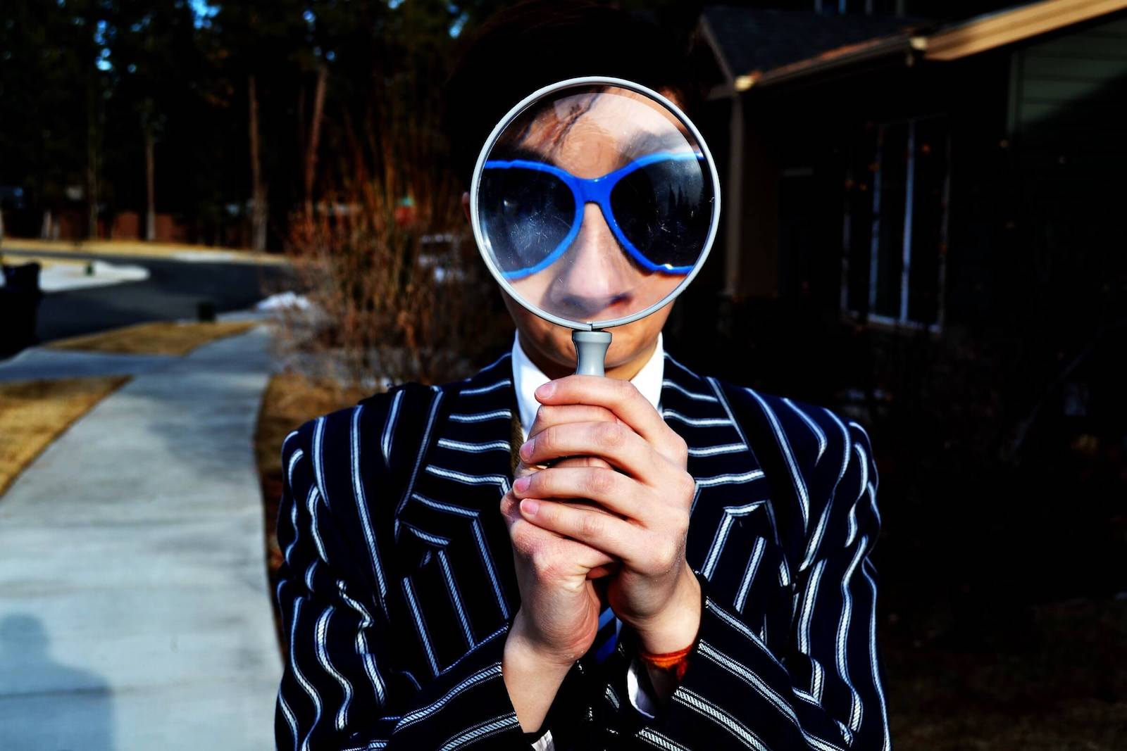 Person looking through a large magnifying glass